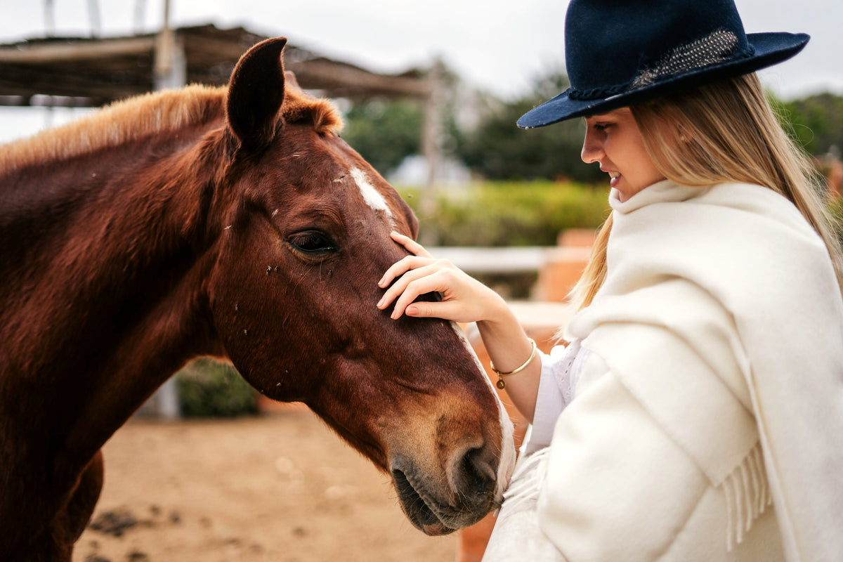 Model in the Natural throw greeting a horse at a Peruvian ranch