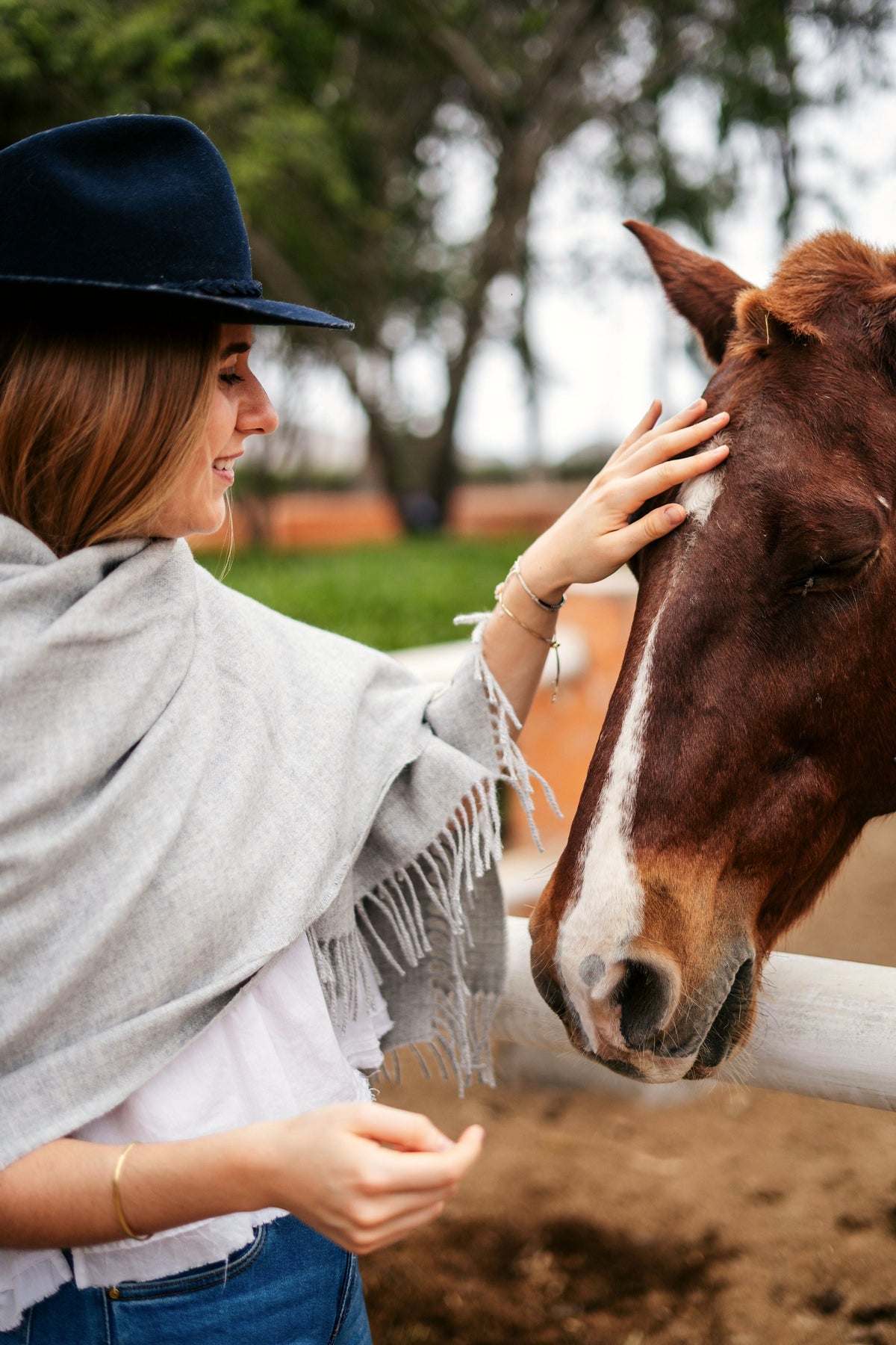 Storm grey alpaca throw, model with a horse at the ranch