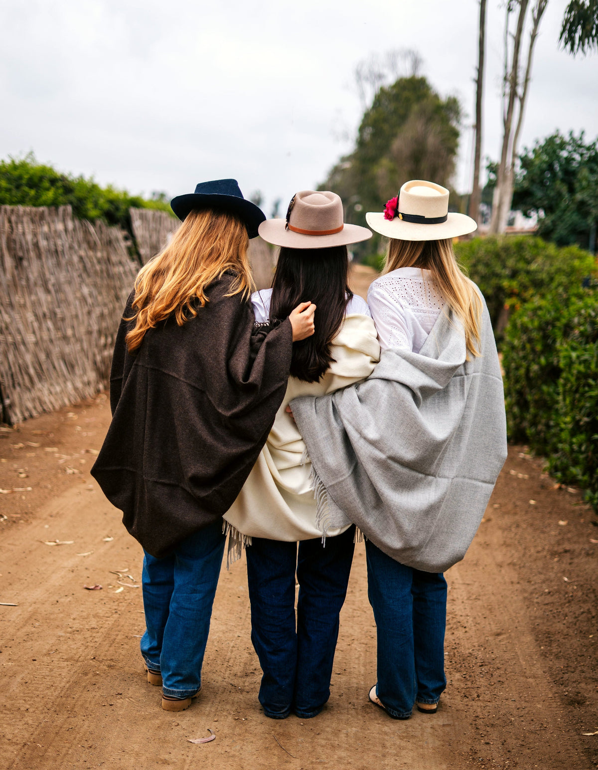 Two models walking with the Storm and Vicuña throws through a field