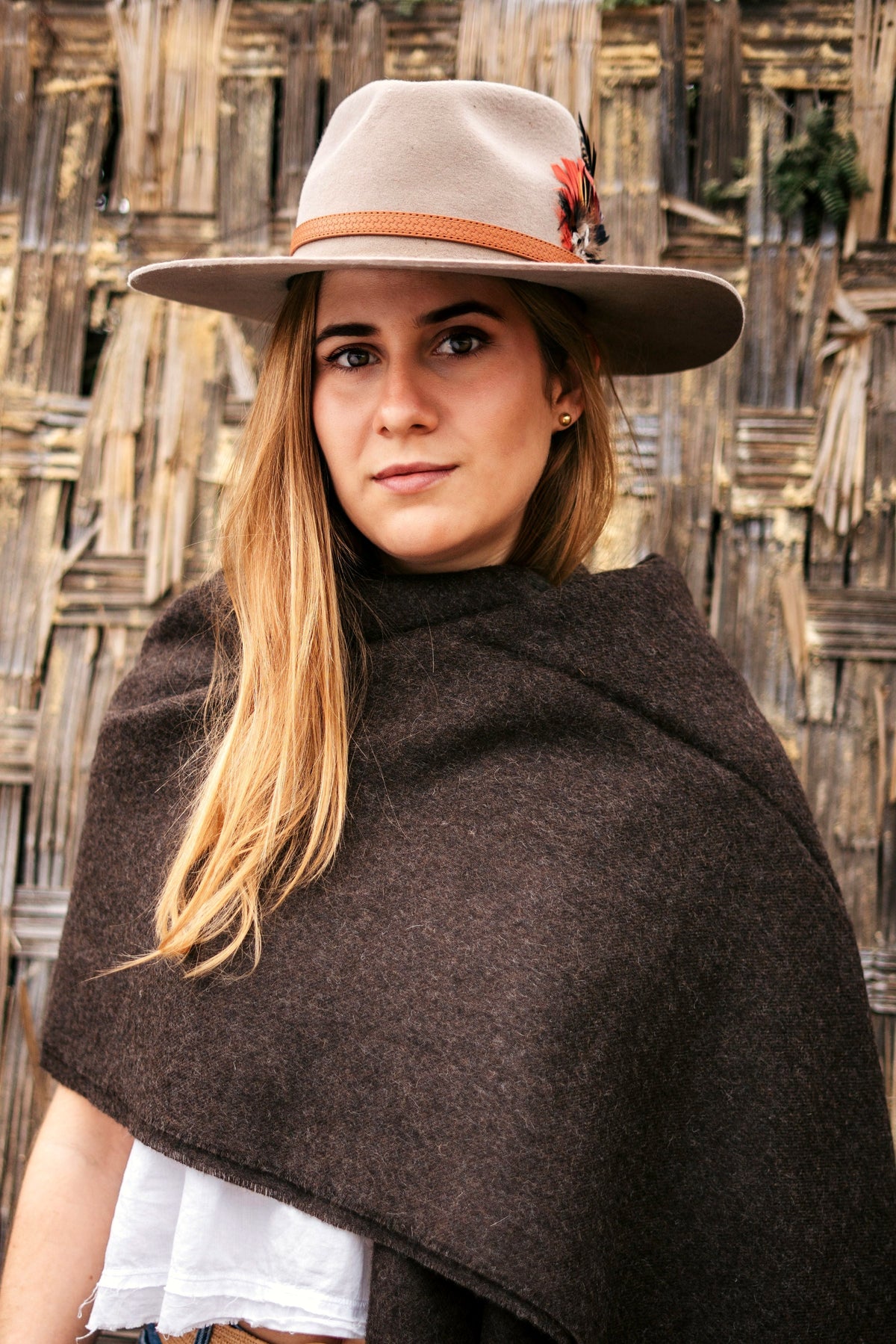 Andean brown baby alpaca throw draped full length, woven cane backdrop