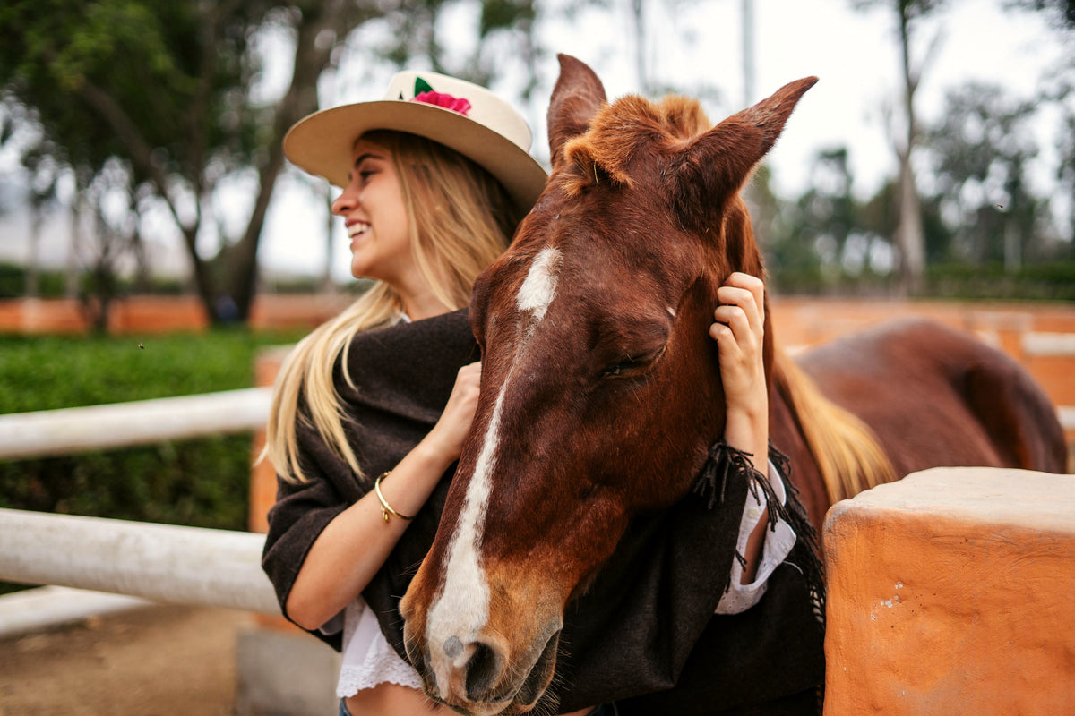Andean brown baby alpaca throw, model embracing a horse