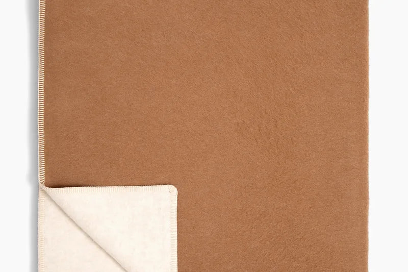 Twin blanket folded to show its ivory reverse