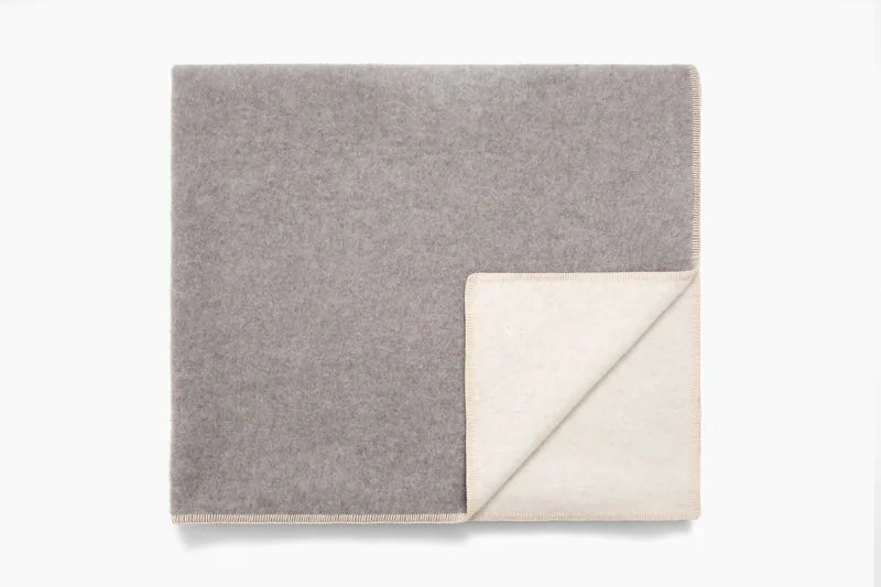 Twin blanket in grey, folded corner with blanket-stitch edge